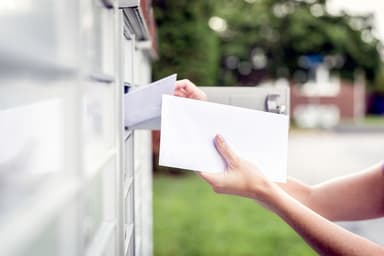 Person retrieves mail from mailbox.